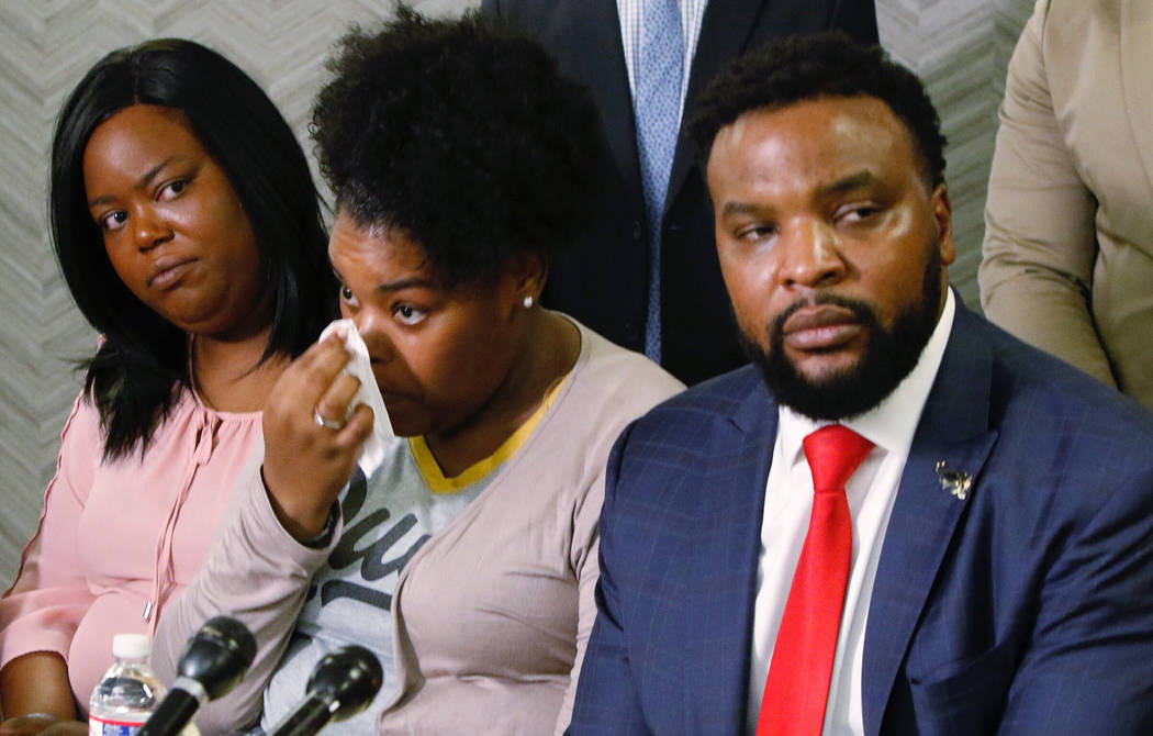 Amber Carr, center, wipes a tear as her sister, Ashley Carr, left, and attorney Lee Merritt, ri ...