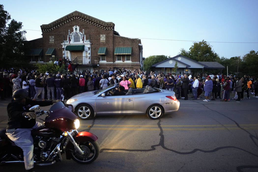A large crowd of protesters gather outside the house, right, where Atatiana Jefferson was shot ...