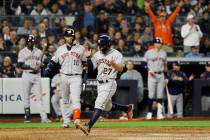 Houston Astros' Jose Altuve celebrates after scoring on a wild pitch during the seventh inning ...