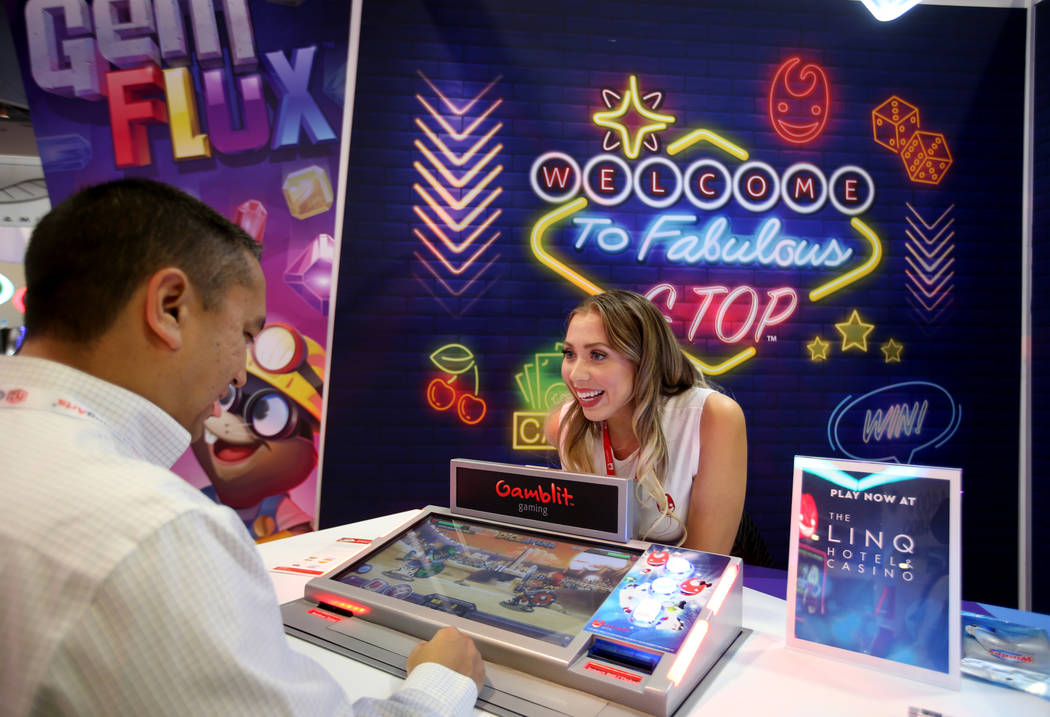 Alexia Bustios of Las Vegas shows Jason Oloriz of Las Vegas how to play the Dice Arena game at ...