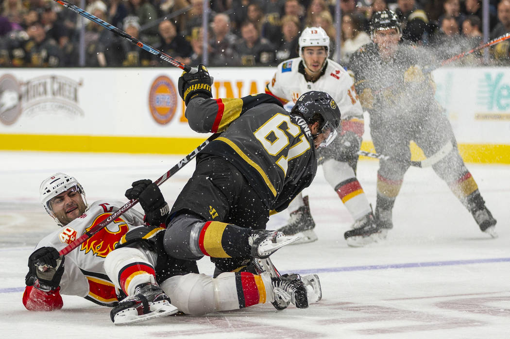 Calgary Flames defenseman Mark Giordano (5, left) takes out Vegas Golden Knights right wing Mar ...