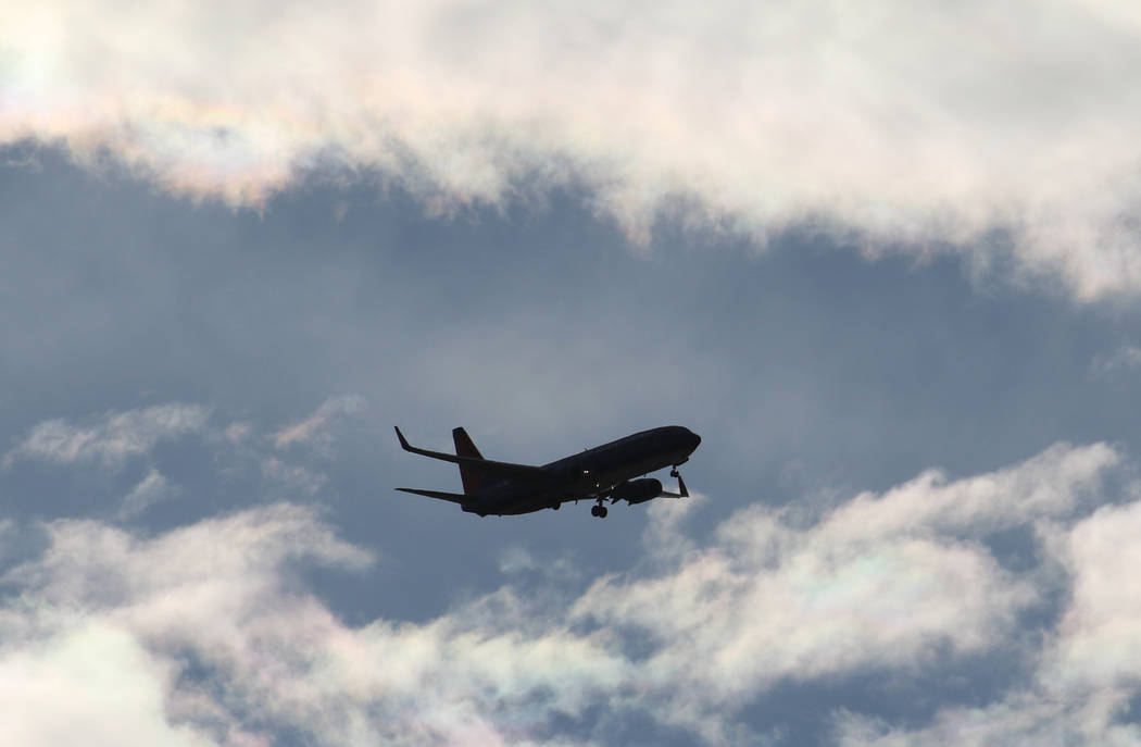 A Sun Country Airlines plane flies under cloudy sky as it approaches McCarran International Air ...