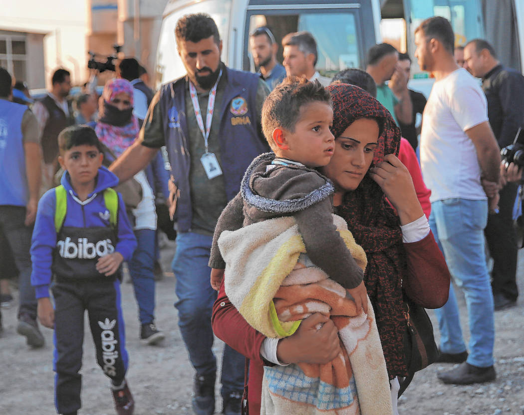 A Syrian woman who is newly displaced by the Turkish military operation in northeastern Syria, ...