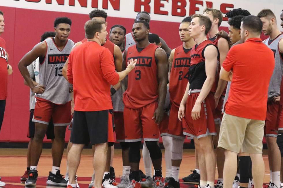 UNLV Rebels head coach T.J. Otzelberger, center, talks to his players after team's first basket ...