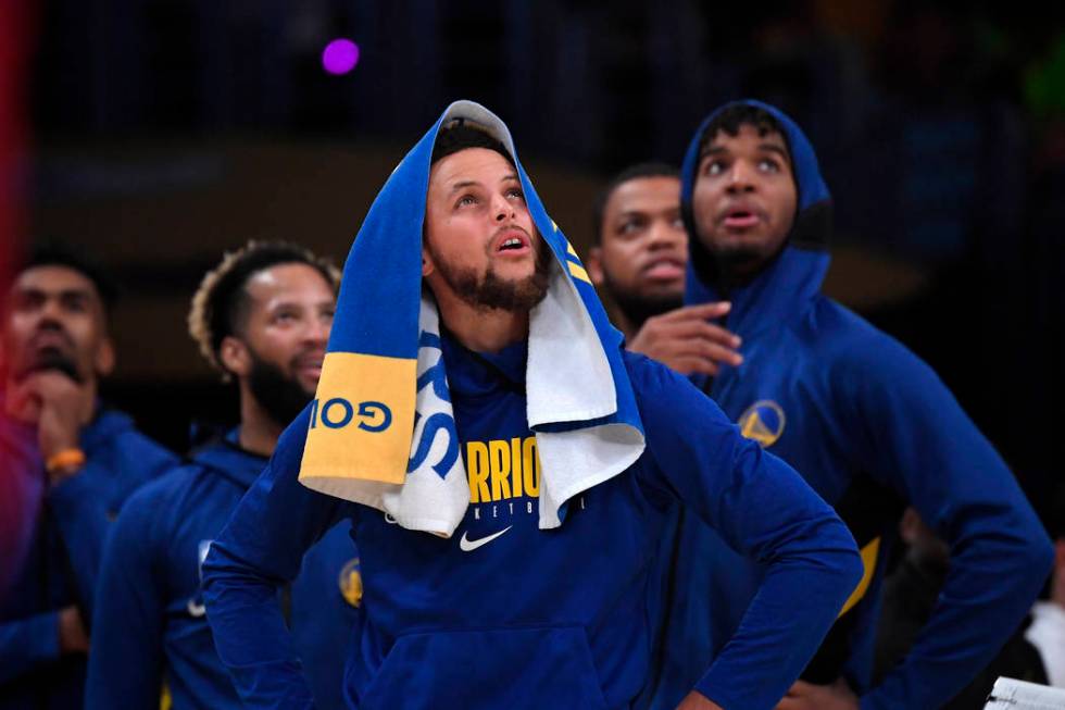 Golden State Warriors guard Stephen Curry looks at a replay along with teammates during the sec ...
