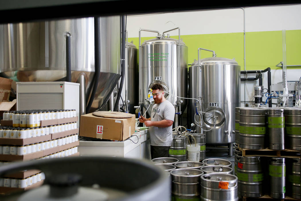 Assistant brewer Bryson Bauducco works on filling a keg order at CraftHaus Brewery in Henderson ...