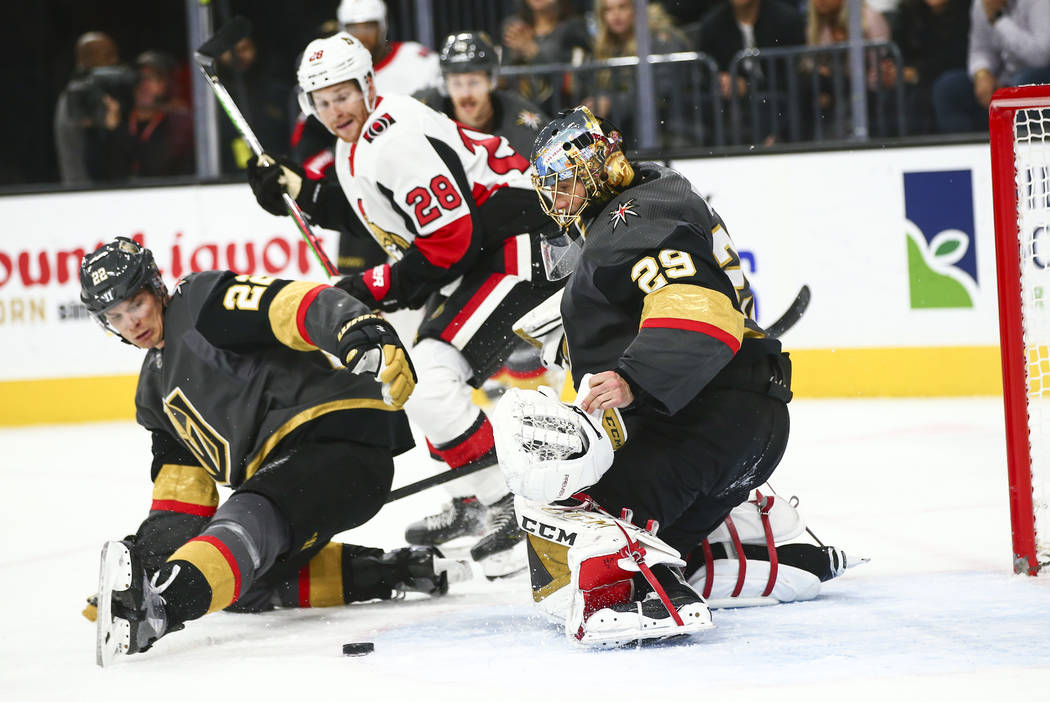 Golden Knights goaltender Marc-Andre Fleury (29) looks to stop the puck after losing his glove ...