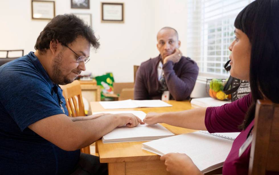 BlindConnect President Raquel O'Neill, right, goes through a Braille lesson with Ivan Medina, l ...