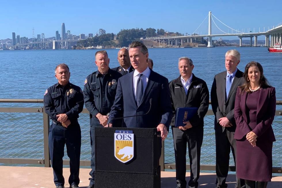 Gov. Gavin Newsom, center, speaks at a news conference with other officials to announce the sta ...