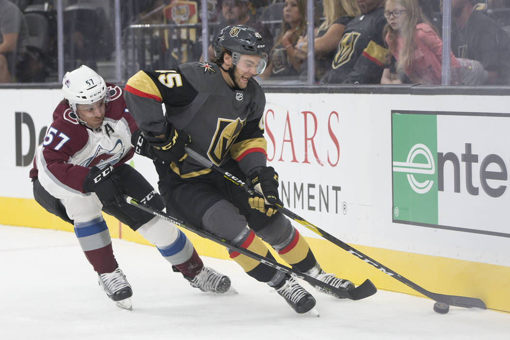 Golden Knights defenseman Jake Bischoff (45) fights for possession with Colorado Avalanche left ...