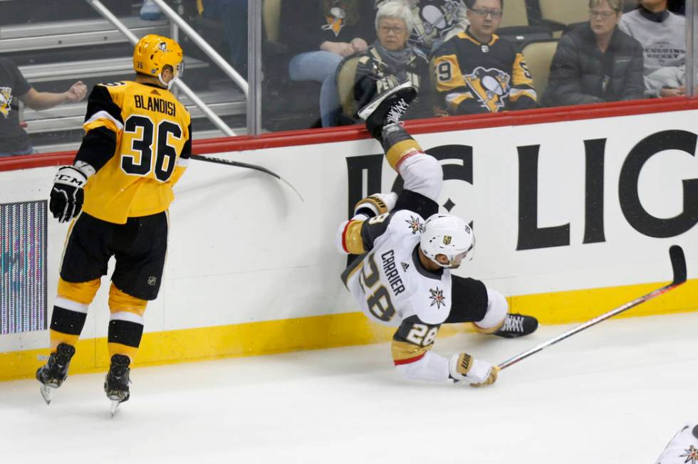 Vegas Golden Knights' William Carrier (28) falls to the ice after a check by Pittsburgh Penguin ...