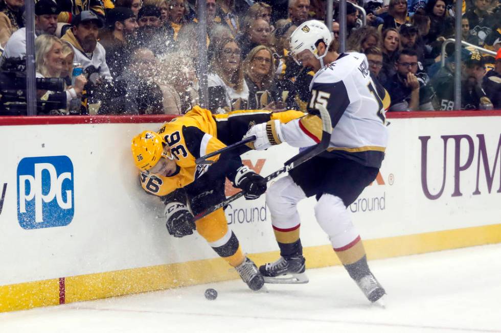 Vegas Golden Knights' Jon Merrill (15) checks Pittsburgh Penguins' Joseph Blandisi (36) into th ...