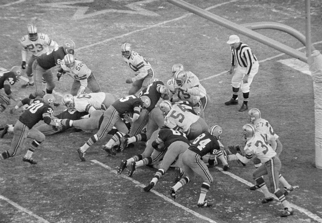 With seconds remaining, quarterback Bart Starr (15), Green Bay Packers, bulls way behind the Pa ...