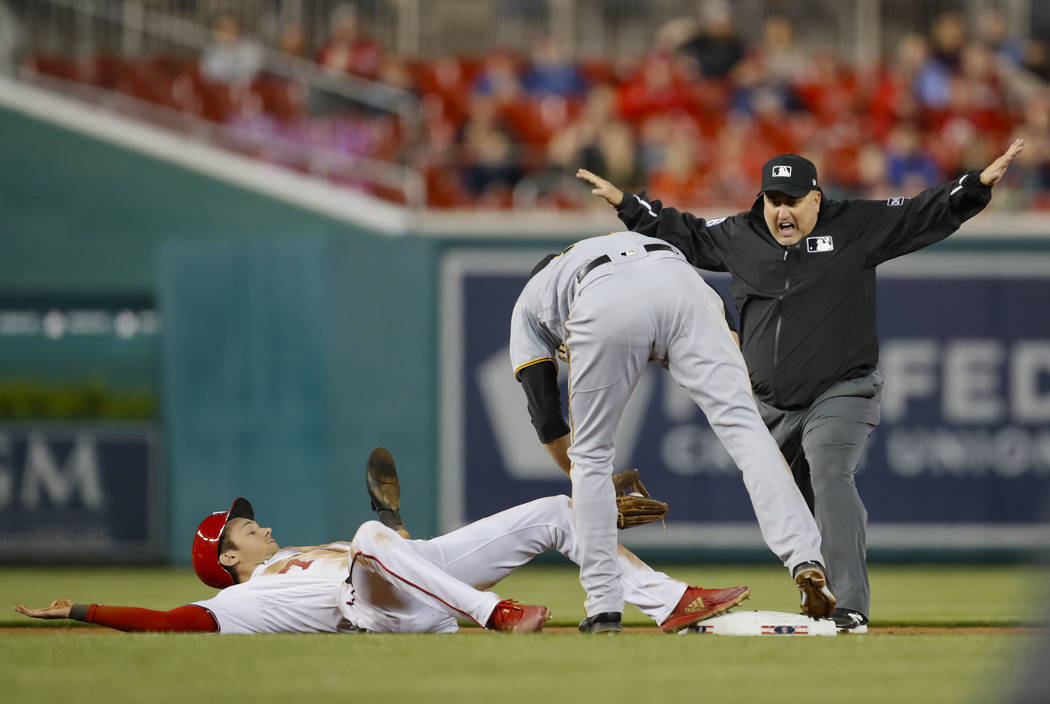 Umpire Eric Cooper, right, calls Washington Nationals' Trea Turner, safe at second ahead of the ...