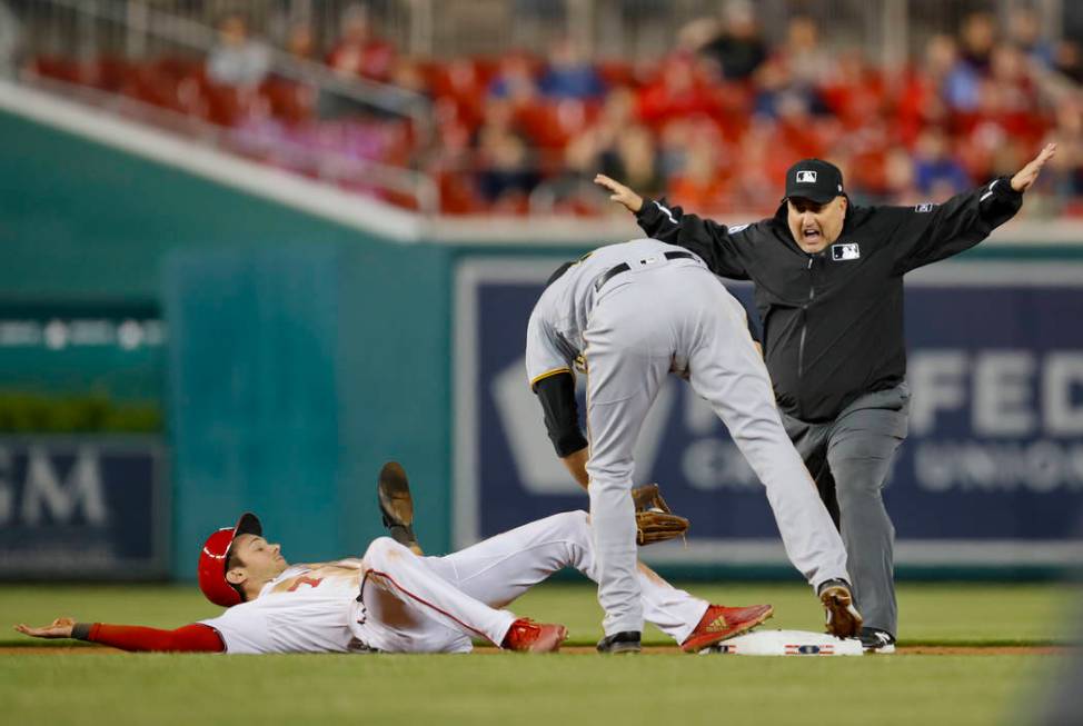 Umpire Eric Cooper, right, calls Washington Nationals' Trea Turner, safe at second ahead of the ...