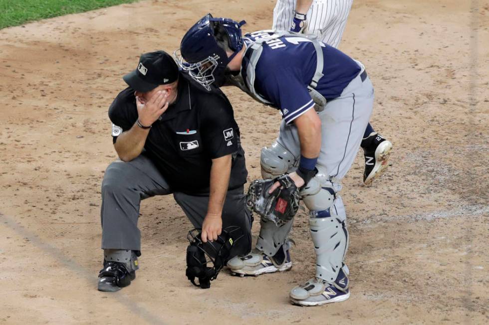 San Diego Padres catcher Austin Hedges, right, checks on home plate umpire Eric Cooper after th ...