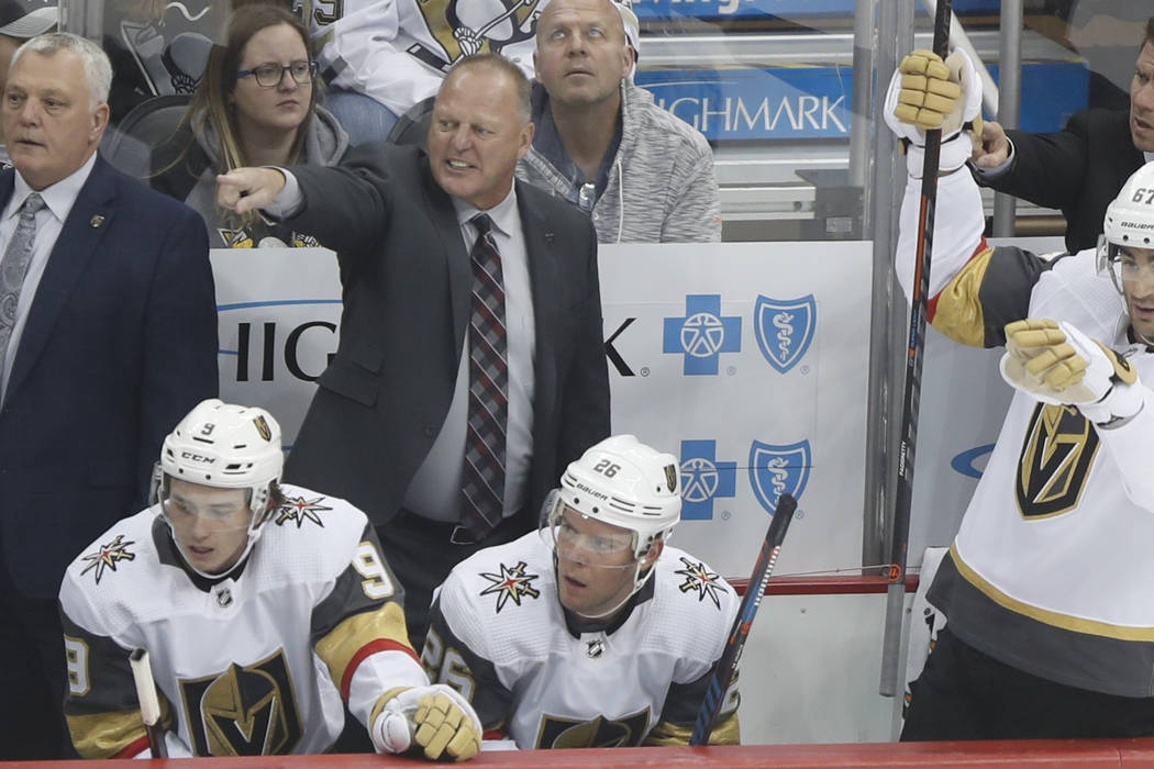 Vegas Golden Knights' Gerard Gallant, center, points down ice during the first period of an NHL ...