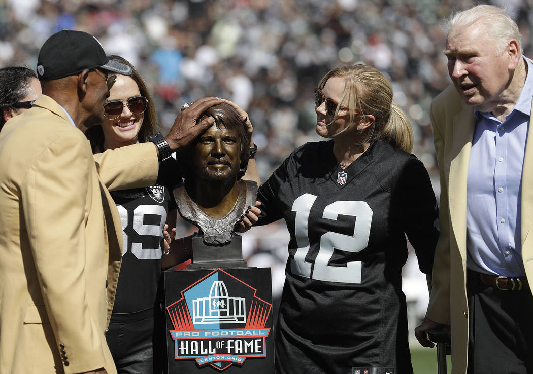 Former Oakland Raiders player Willie Brown, left, and former head coach John Madden, right, sta ...