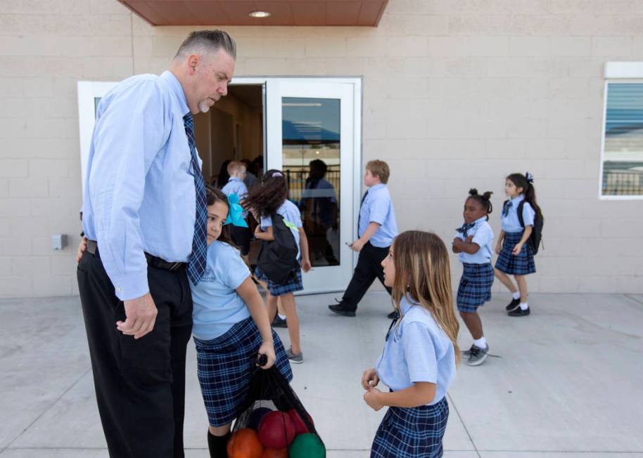 Carey Roybal-Benson, principal of Signature Preparatory, accepts a hug from third grader Paisle ...