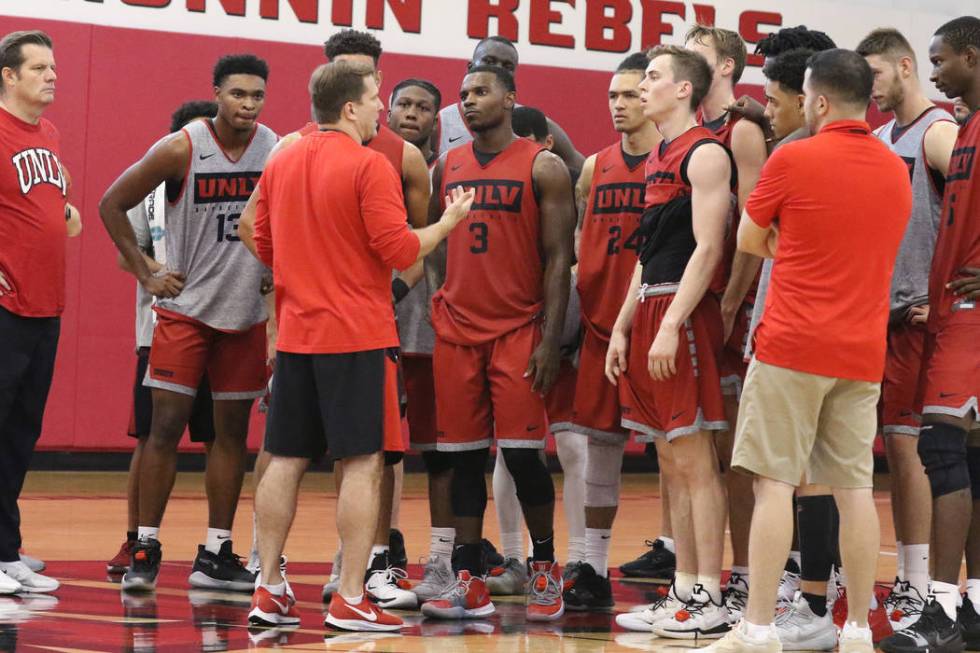 UNLV Rebels head coach T.J. Otzelberger, center, talks to his players after team's first basket ...