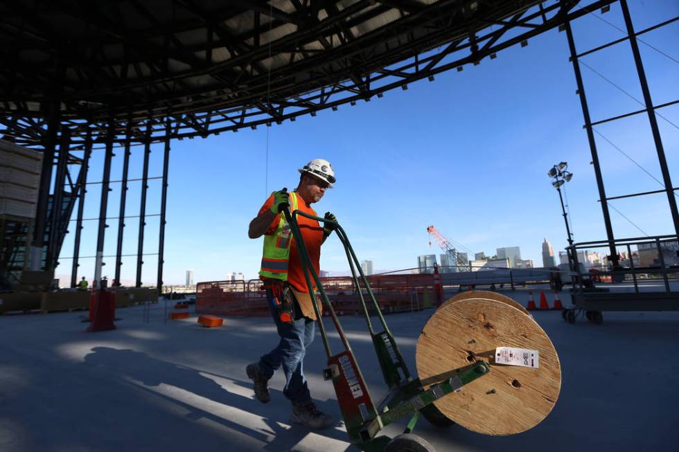 Electrical worker Randy, who declined to give his last name, moves equipment inside the Raiders ...