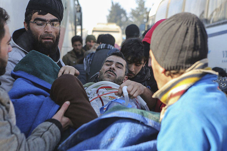 An injured Syrian arrives at a refugee camp in Rashidin, near Idlib, Syria, after was evacuated ...