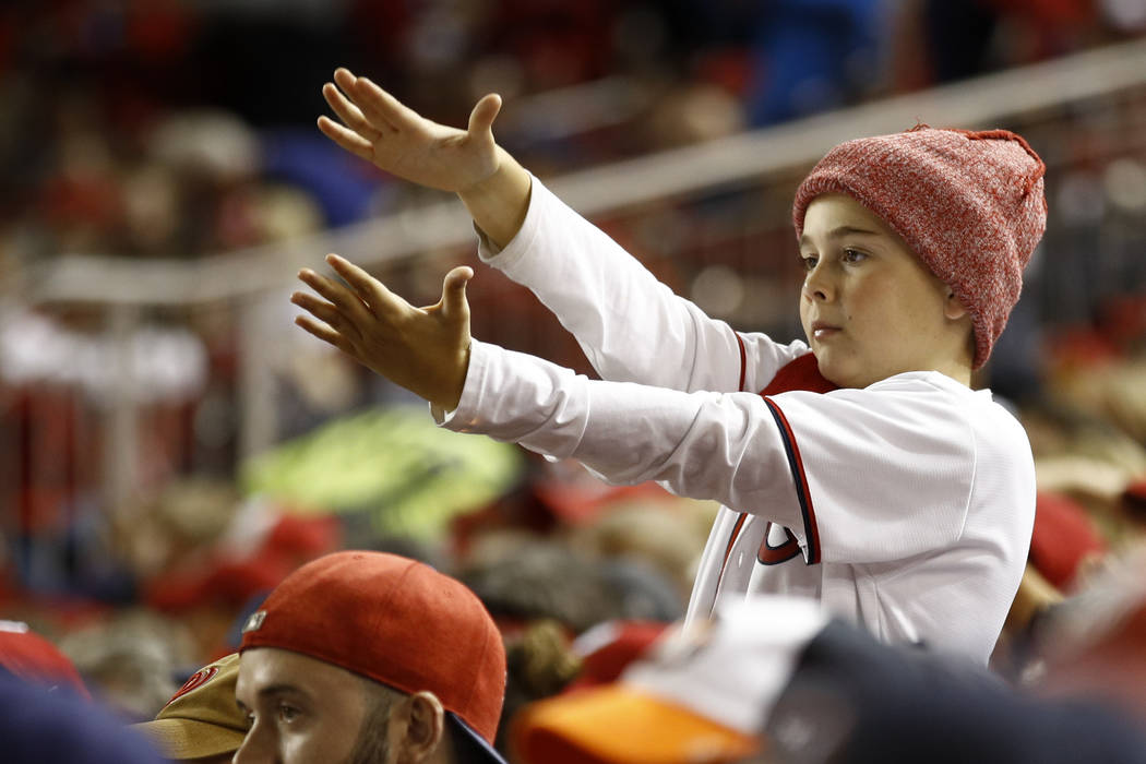 A fan gestures the baby shark as Washington Nationals' Gerardo Parra bats during the sixth inni ...