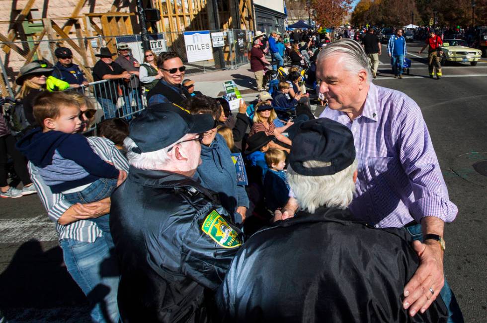 Gov. Steve Sisolak greets Dan Dulong, left, and Fred Webb, volunteers with the Carson City Sher ...