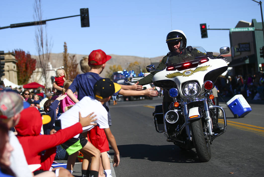 A member of the Carson City Sheriff's Office high-fives attendees during the annual Nevada Day ...
