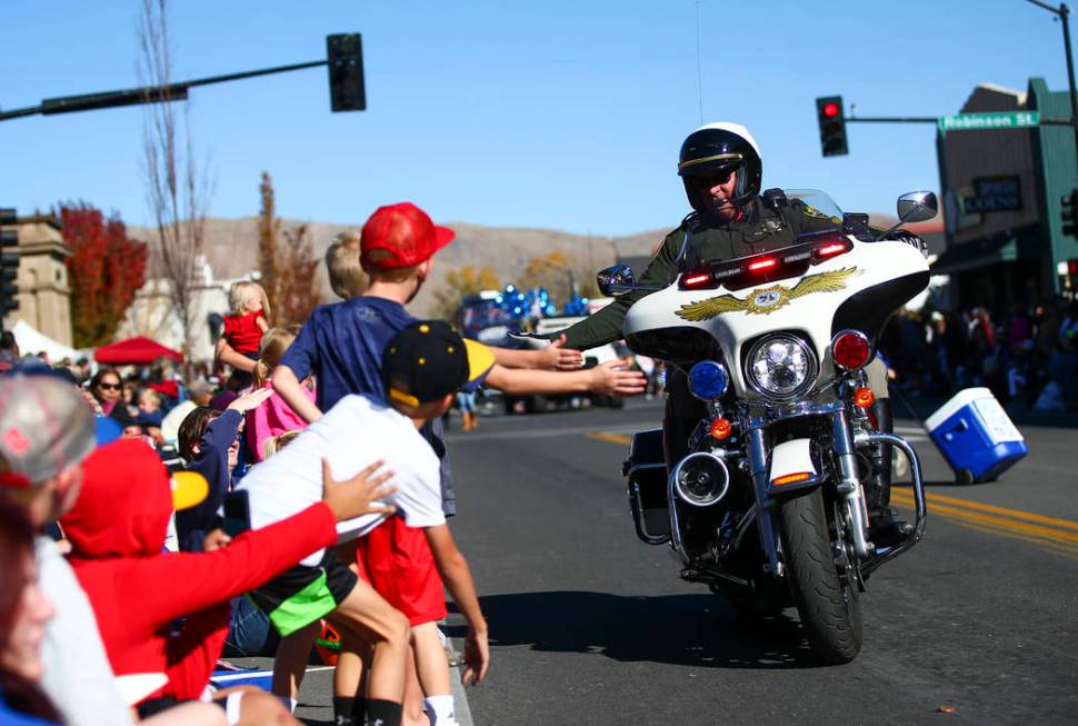 A member of the Carson City Sheriff's Office high-fives attendees during the annual Nevada Day ...