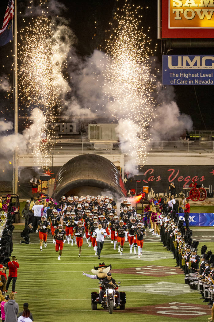 UNLV players and coaches take the field versus San Diego State for their football game at Sam B ...