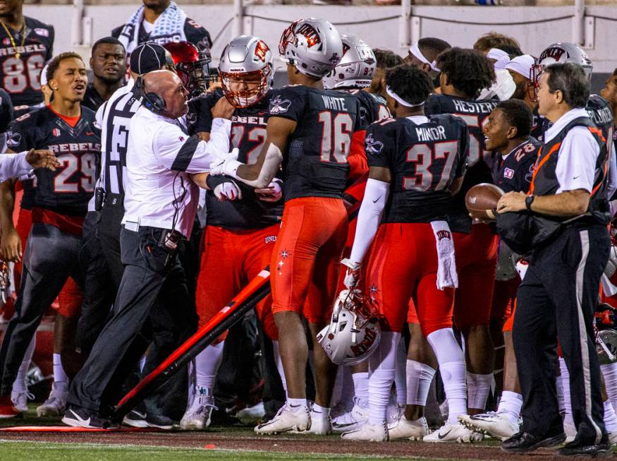 UNLV Rebels head coach Tony Sanchez attempts to control his offensive lineman Matt Brayton (72) ...