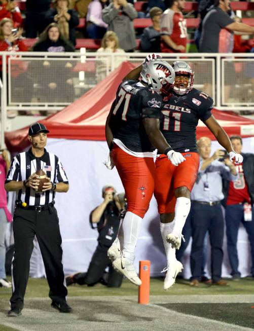 UNLV Rebels offensive lineman Justice Oluwaseun (71) celebrates a touchdown by teammate tight e ...