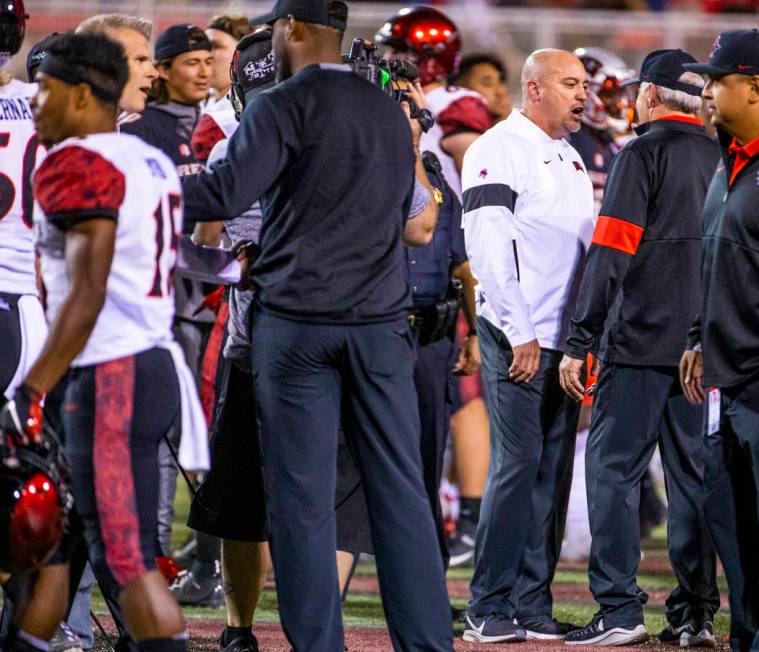 UNLV Rebels head coach Tony Sanchez chats with San Diego State Aztecs head coach Rocky Long at ...