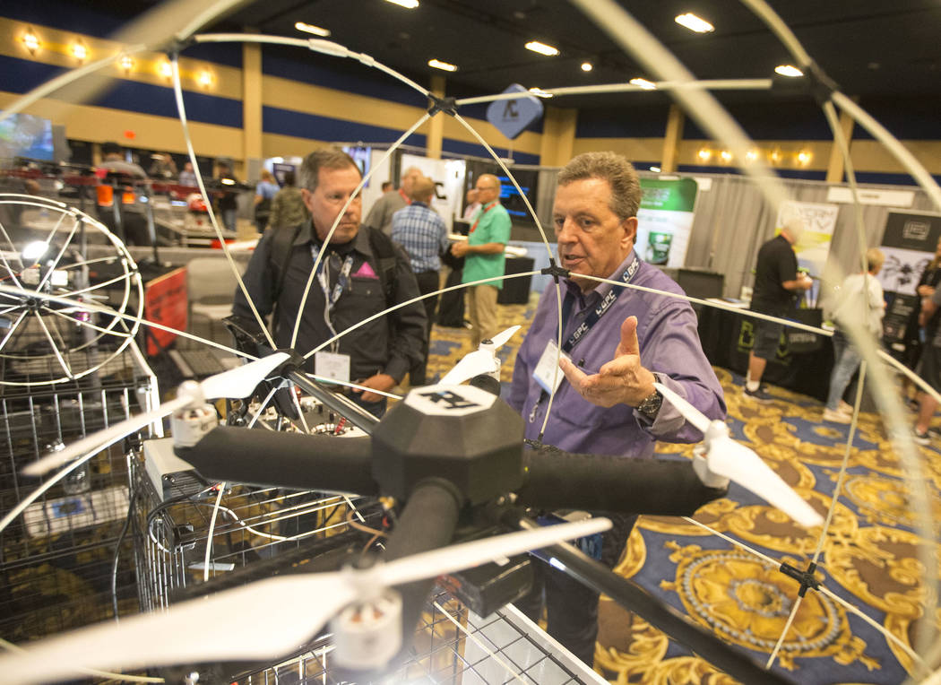 R4 Robotics Inc. president Karl Sachs, right, demos his R4 Roller drone, developed with a lined ...