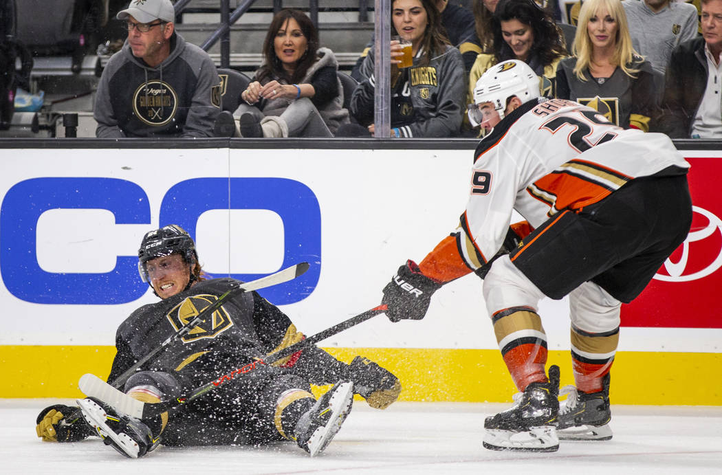 Vegas Golden Knights center Cody Eakin (21) is taken down to the ice by Anaheim Ducks center De ...