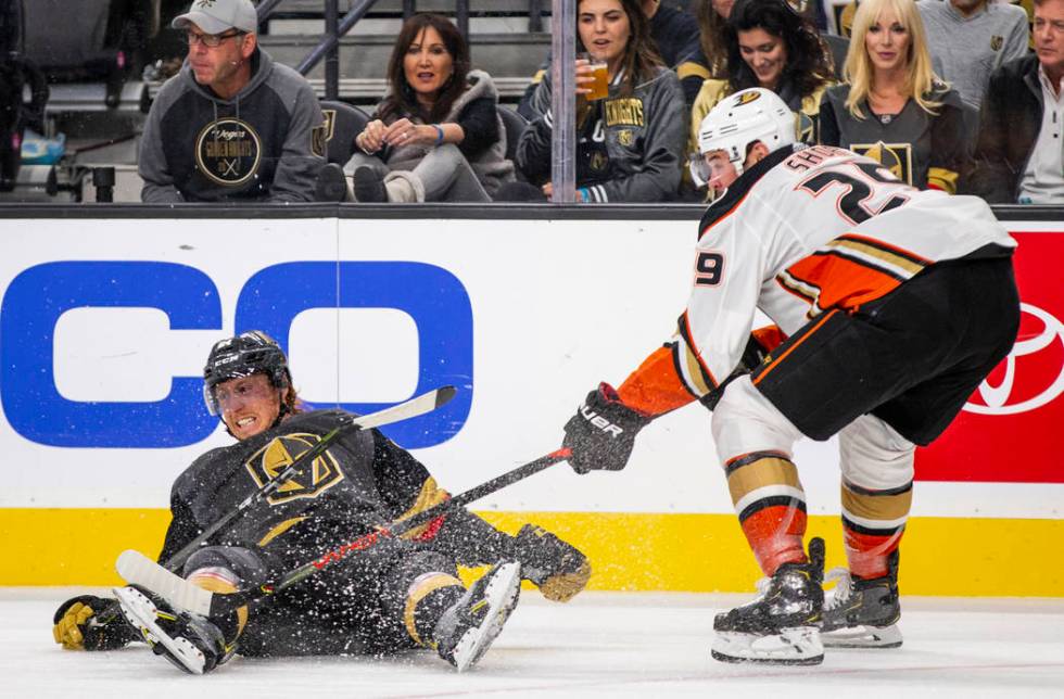 Vegas Golden Knights center Cody Eakin (21) is taken down to the ice by Anaheim Ducks center De ...