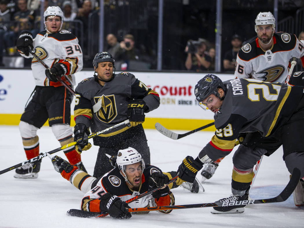 Vegas Golden Knights left wing William Carrier (28, right) looks to the puck after taking down ...