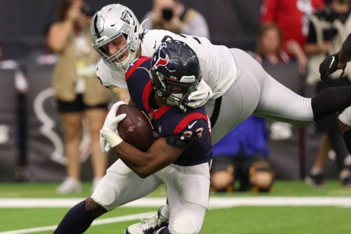 Oakland Raiders defensive end Maxx Crosby (98) grabs the facemask of Houston Texans running bac ...