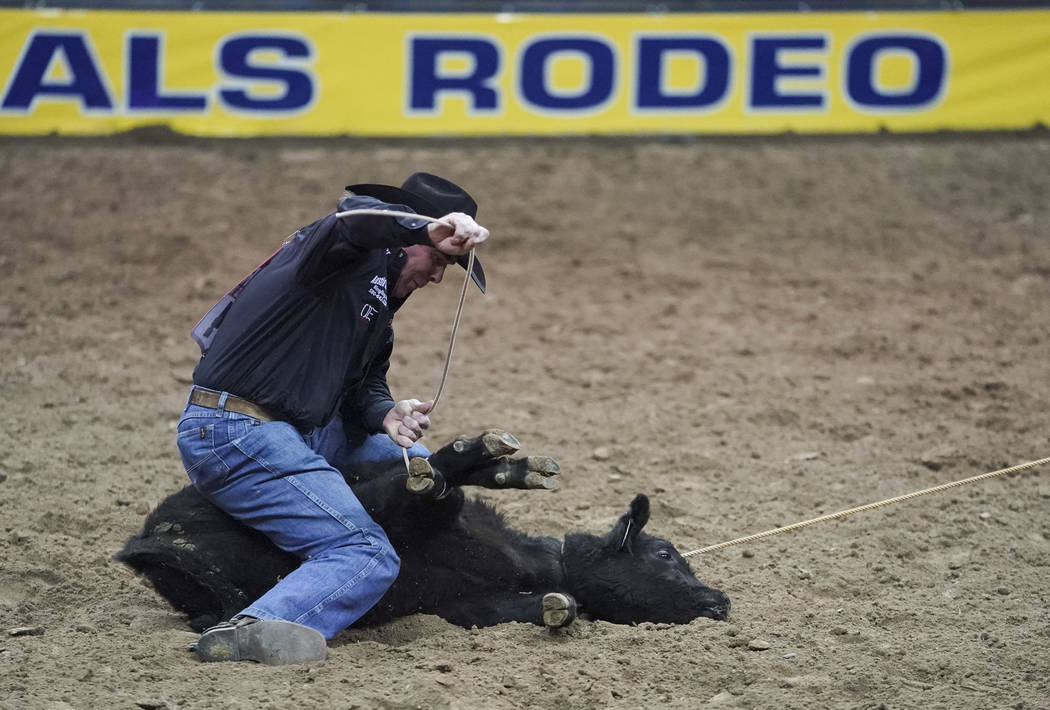 Ryan Jarrett of Comanche, Okla (94) competes in the tie-down roping event during the eighth go- ...