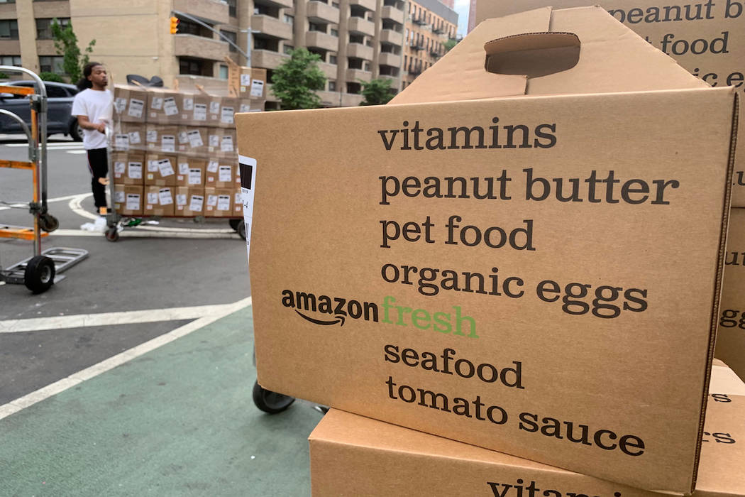 In this Sunday, June 16, 2019, photo, boxes of Amazon Fresh deliveries are unloaded. (AP Photo/ ...
