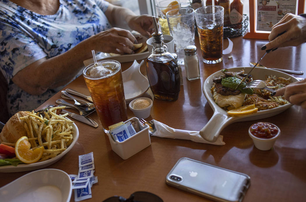 Neighbors Jan Fisher and Linda Johnson, both who live in the Royal Highlands neighborhood, eat ...