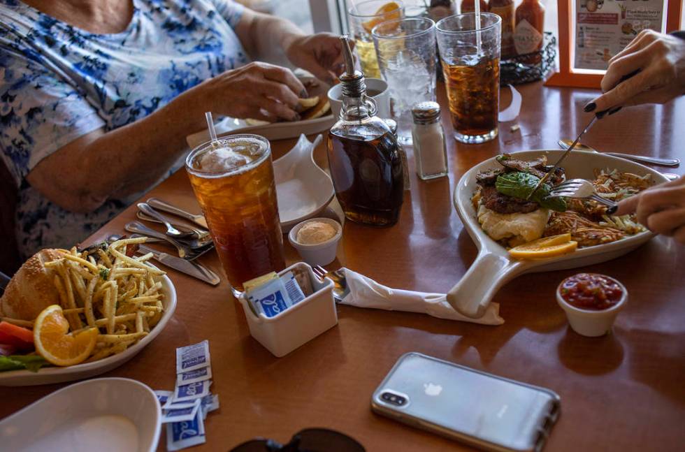 Neighbors Jan Fisher and Linda Johnson, both who live in the Royal Highlands neighborhood, eat ...