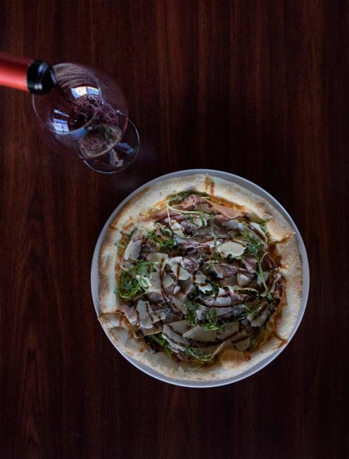 Bar lead David Cooper pours a glass of red wine to pair with the "San Daniele" pizza at Spaghet ...