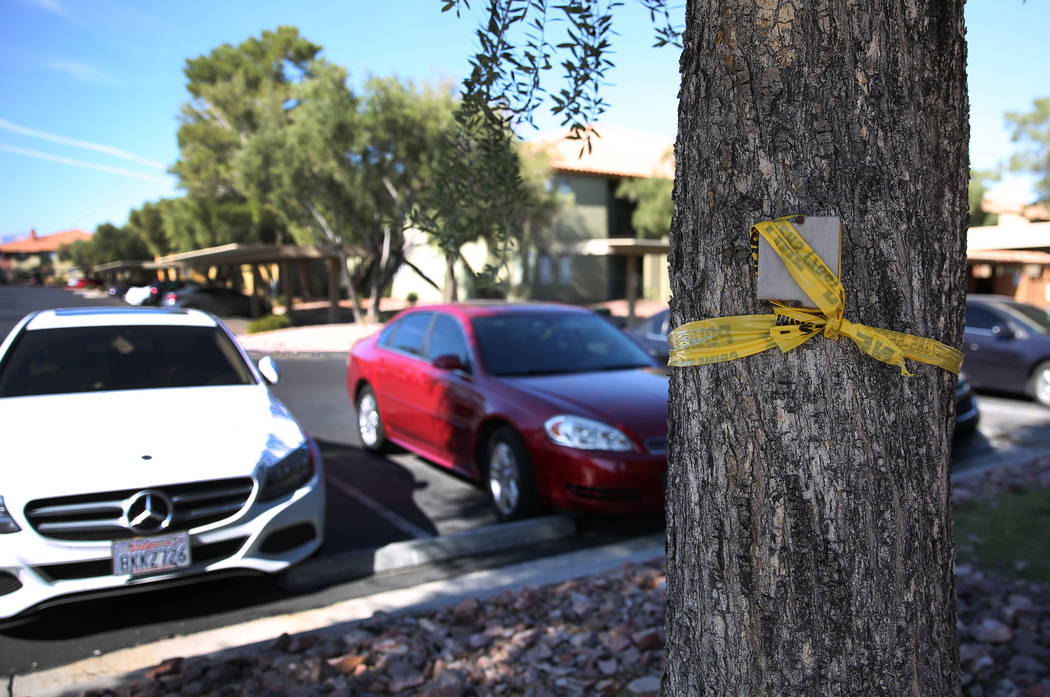 A portion of yellow police tape marks the crime scene at the Indian Hills Apartments complex at ...