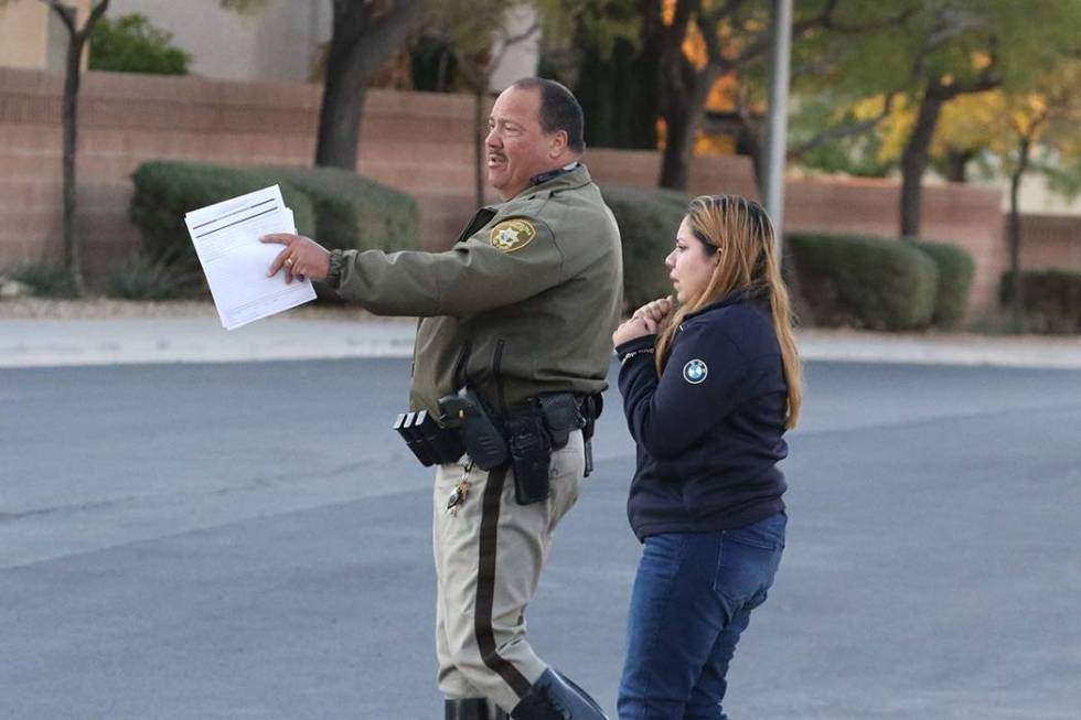 A Las Vegas police officer talks to one of the drivers involved in a two-car crash at West Ford ...