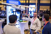 Eric Torres, middle, with Innoflight Technology, discusses the Snoopy CL-90 drone during the Co ...