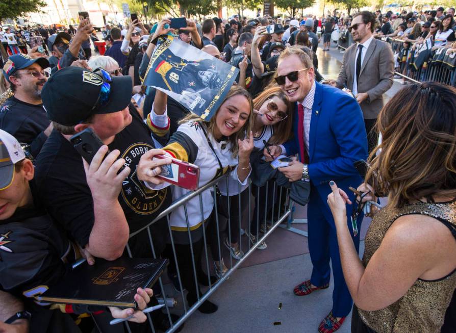 Golden Knights' Nate Schmidt poses for pictures on the gold carpet after arriving for the NHL s ...