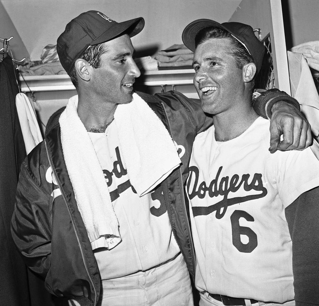 Dodger left hander Sandy Koufax, left, gets congratulations from outfielder Ron Fairly after wi ...