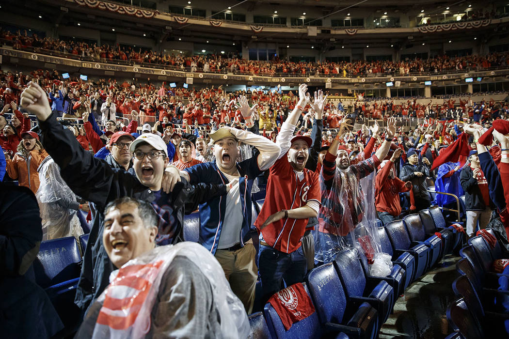 Washington Nationals fans celebrate at Nationals Park in Washington while watching television c ...